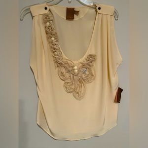 100% silk camisole with embroidered details along the top. Flowy fit.